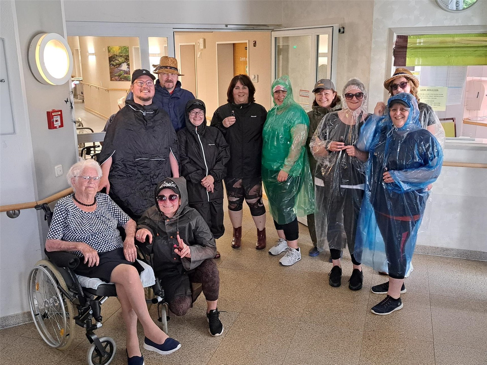 Eine Gruppe von Menschen in Regenkleidung posiert lächelnd für ein Foto.